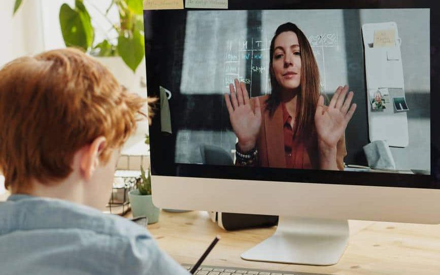 photo of boy video calling with a woman through imac