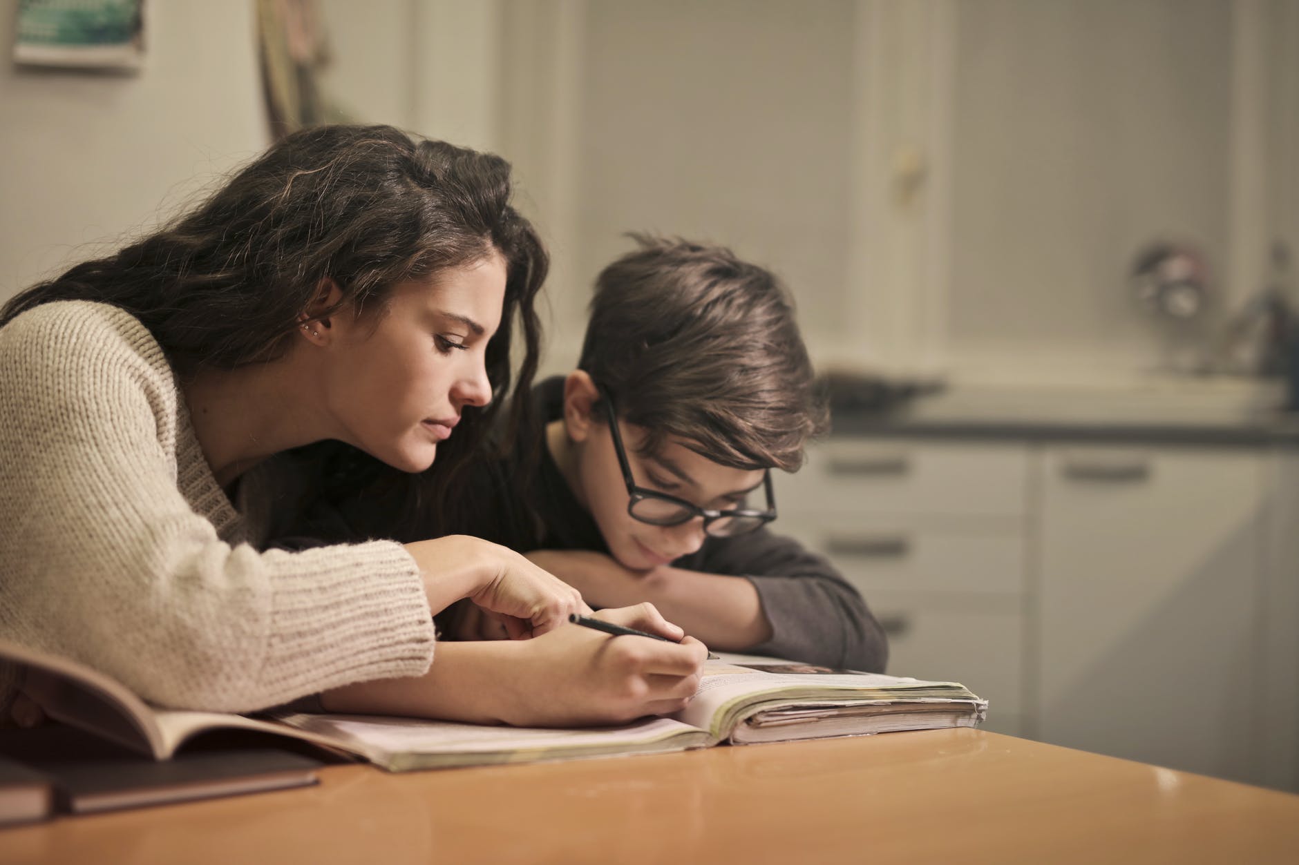 Mother supporting her kid to read