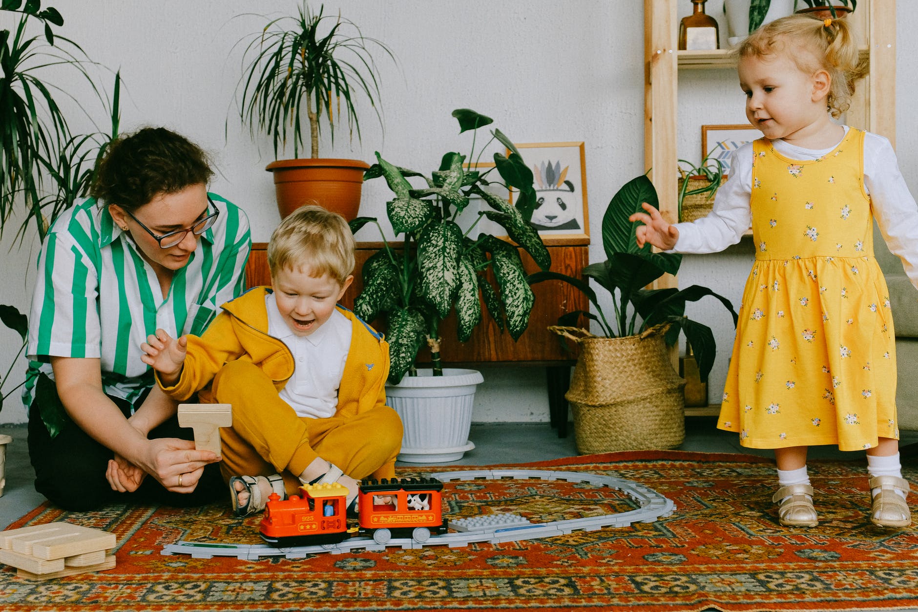 mother and two siblings helping their children to read by having a game system