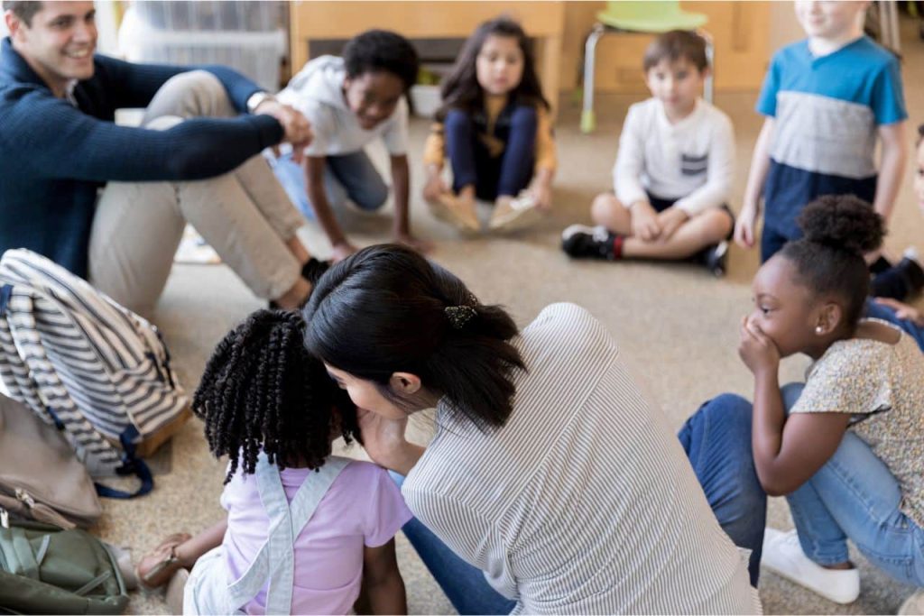 Adults and children playing the telephone game.